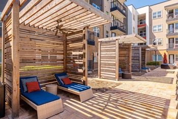 A wooden patio with a blue cushioned chair and a table. at Bridge at Henley, Austin, TX